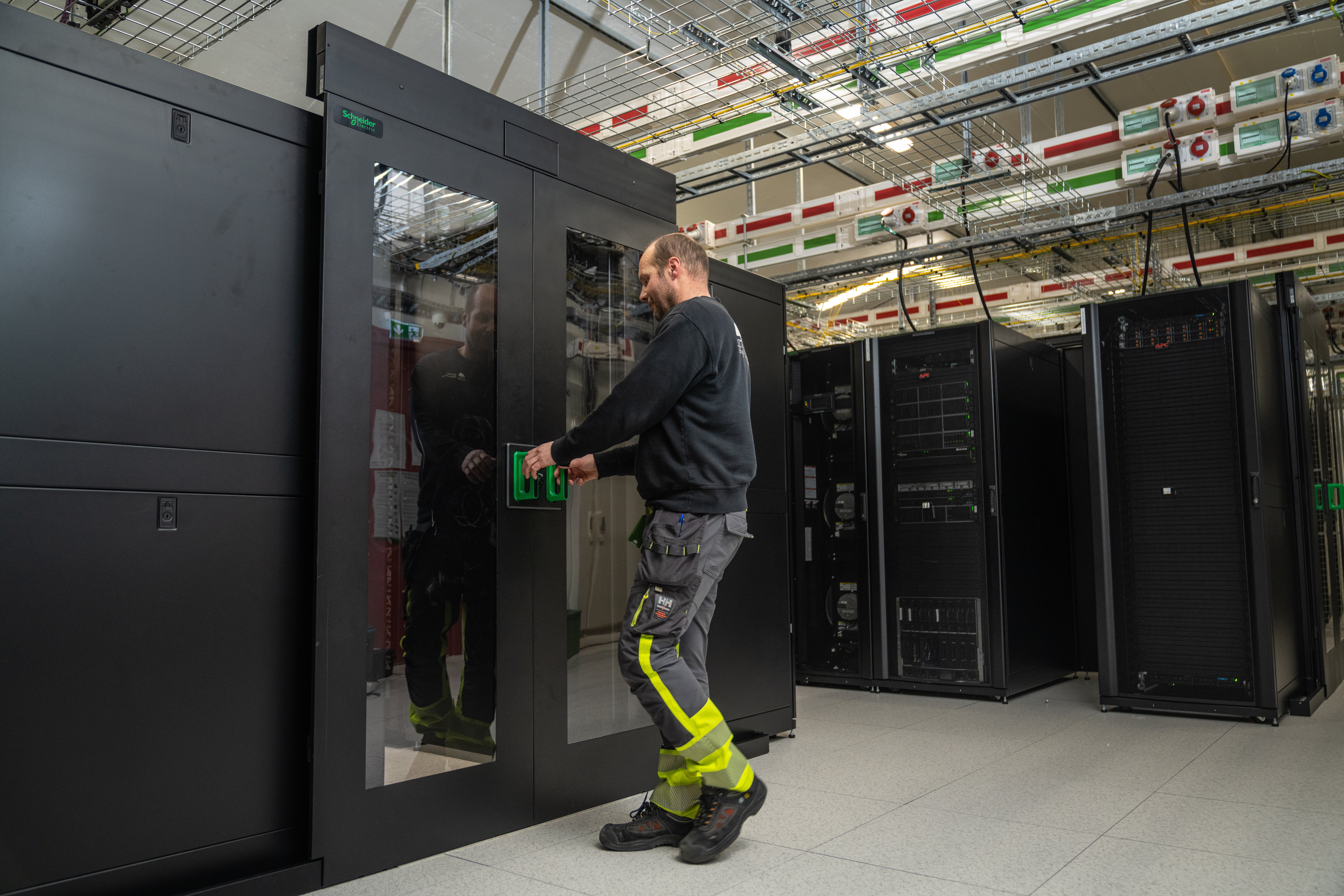 Server technician opening server doors at a data centre -Maverix Media_Innovation Norway